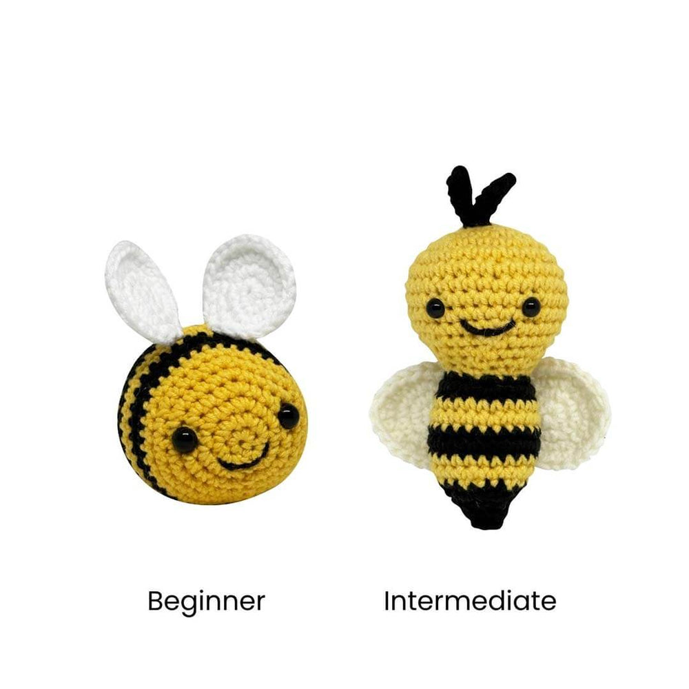 Two crocheted bumblebee figures on a white background, labeled Beginner and Intermediate. The left bee is smaller with white wings, and the right bee is larger with white wings.