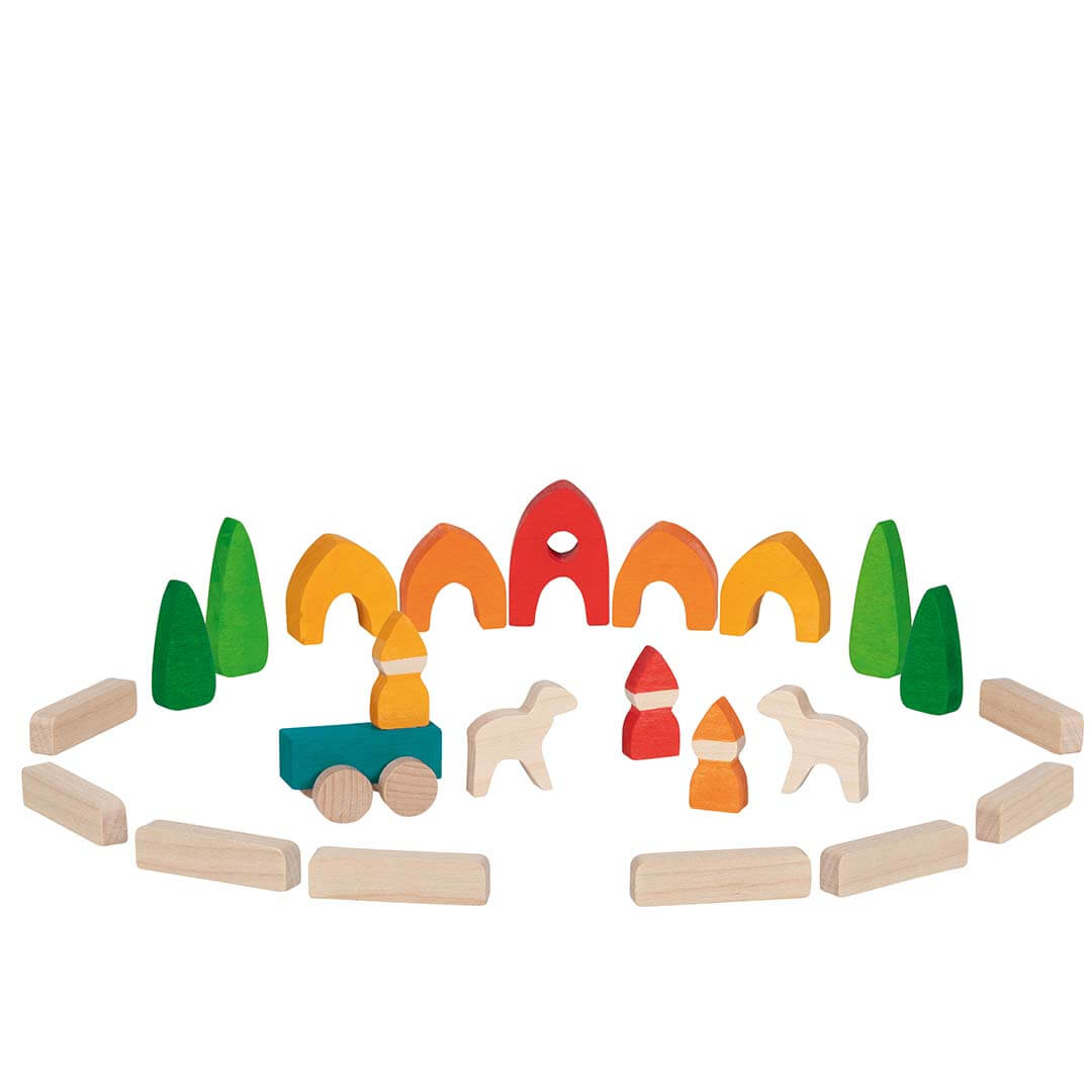 A children's wooden toy set arranged on a white background, including colorful arches, trees, small houses, and natural wood animal and block pieces.