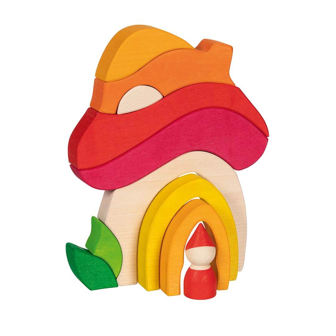 A wooden toy house puzzle with a red mushroom-shaped roof, yellow and orange arched doorway, green leaf detail, and two loose orange and yellow pieces on a white background.