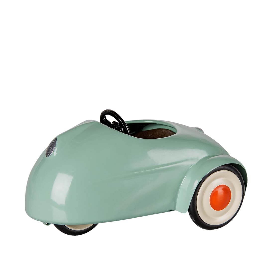 A vintage-style sage pedal toy car with black wheels and a black steering wheel, shown against a plain white background.