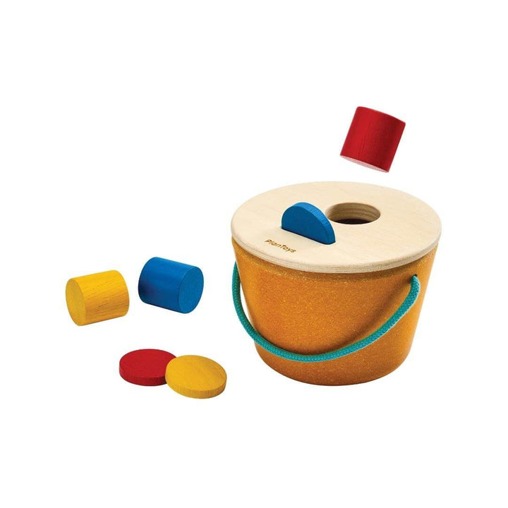 PlanToys Montessori Drop & Fit Bucket with colorful wooden shapes in red, yellow, and blue, designed for shape-sorting and Montessori learning play.