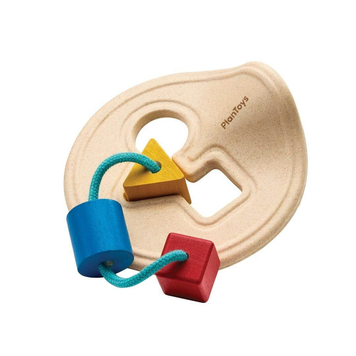 PlanToys Montessori First Shape Sorter with a natural wood base and three colorful shapes—red square, yellow triangle, and blue cylinder—threaded on a teal cord.