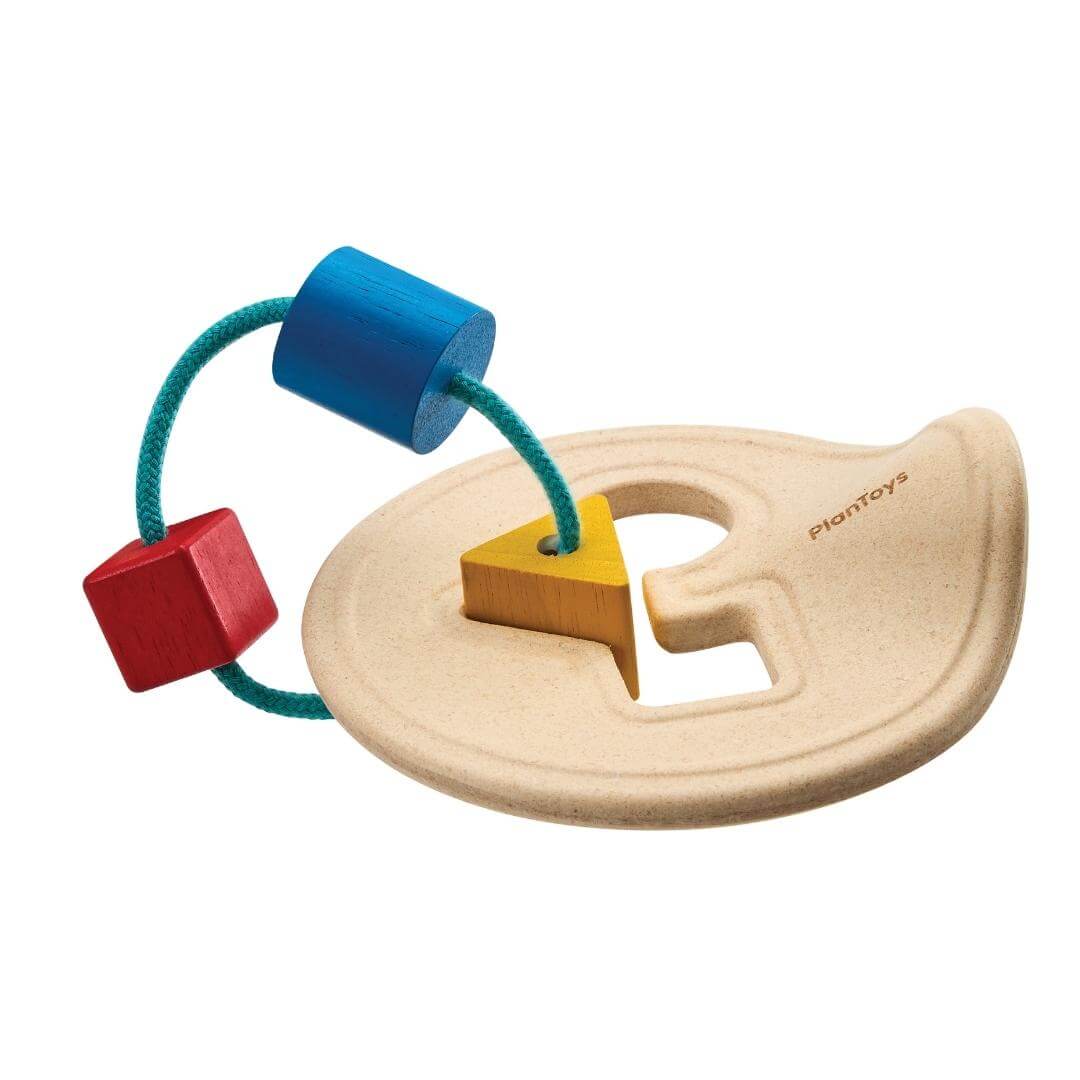 PlanToys Montessori First Shape Sorter with a natural wood base and three colorful shapes—red square, yellow triangle, and blue cylinder—threaded on a teal cord.
