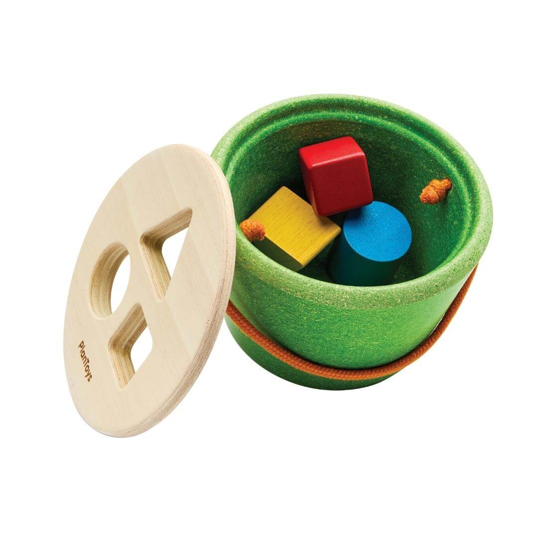 PlanToys Geo Shape Sorter Bucket with colorful wooden shapes and green base shown with the top off. 
