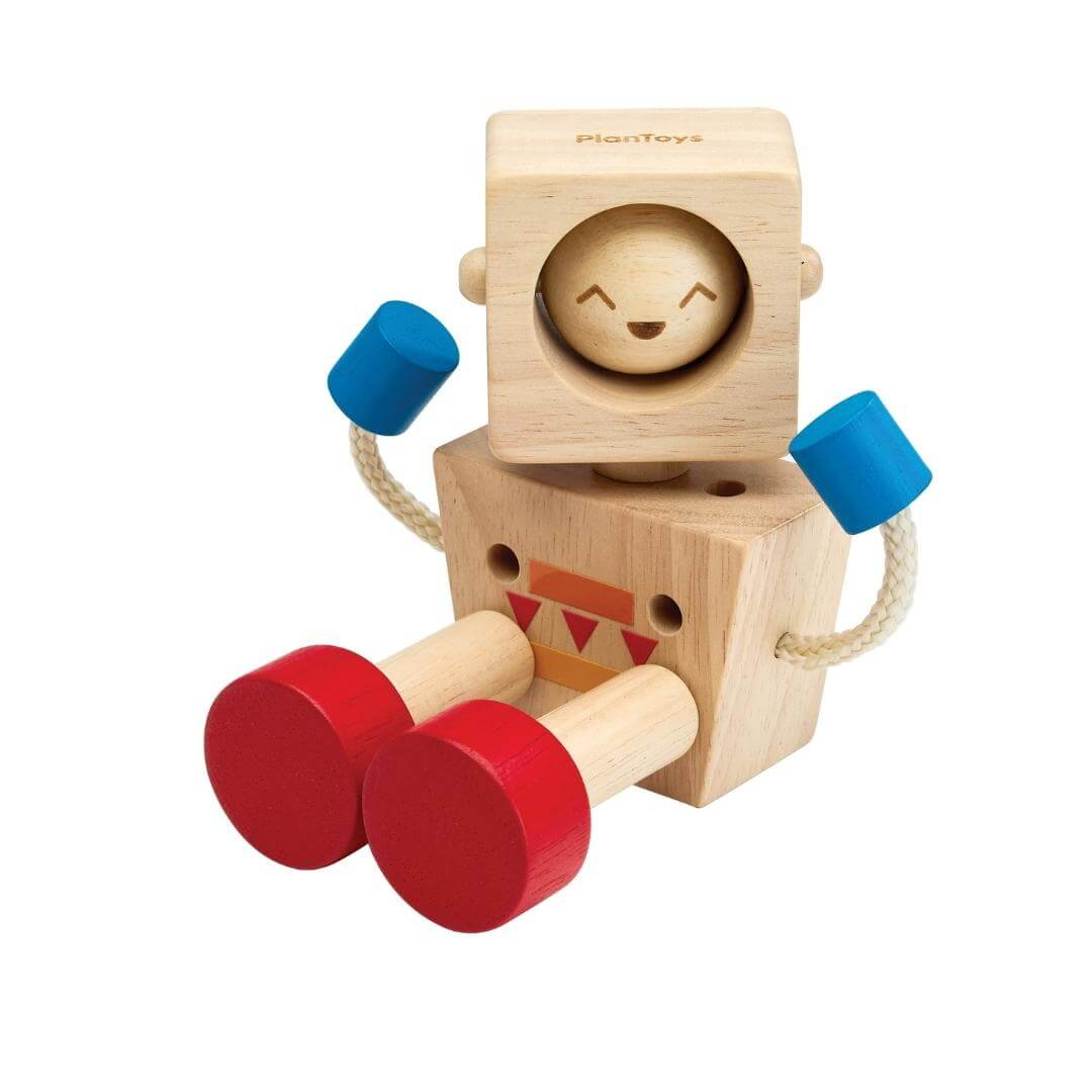 Seated PlanToys Montessori Moodbot Wooden Robot with changeable facial expressions, poseable arms and legs, made from natural wood with red feet and blue hands.