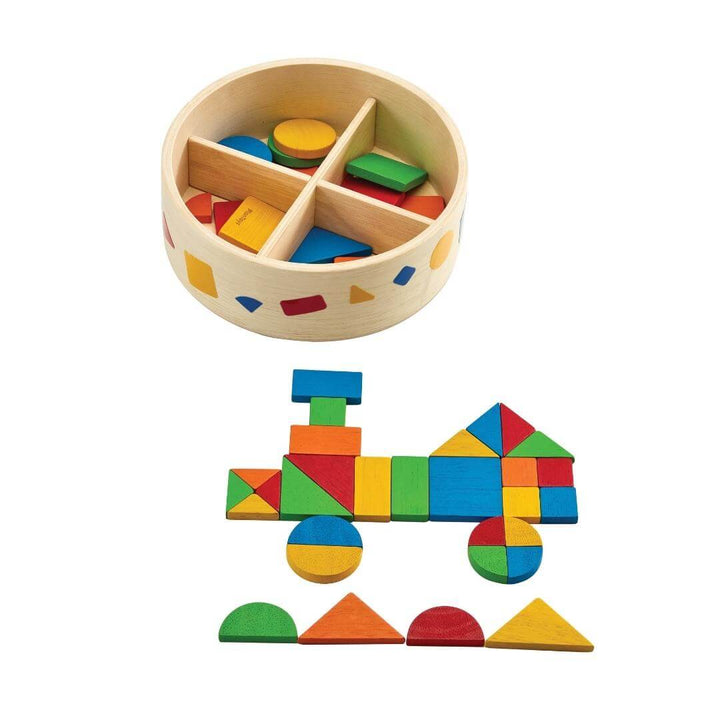 PlanToys Montessori Mosaic Shape Set with round wooden container and colorful geometric tiles arranged into the shape of a train on a white background.