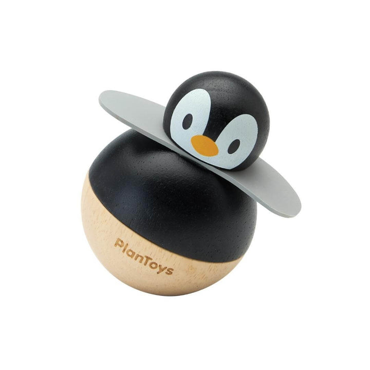 PlanToys Montessori Rolly Penguin wobbling toy made from rubberwood, with a high-contrast black-and-white design and rounded base for rocking movement.