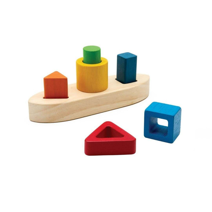 PlanToys Montessori Shape Sorting Boat Puzzle with natural wood boat base and colorful red, yellow, green, and blue geometric blocks for shape-sorting play.