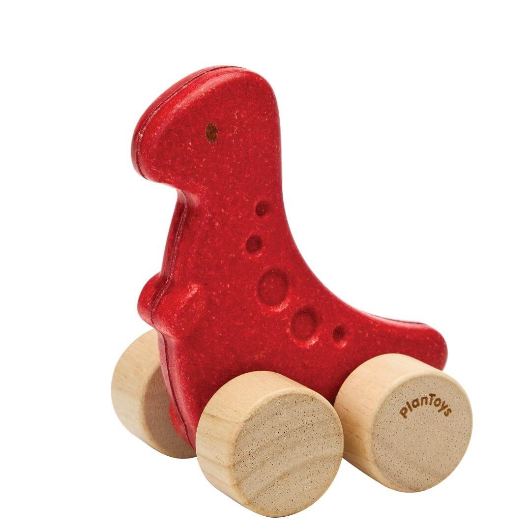PlanToys Montessori Dino Rex Car in red, shaped like a T-Rex with four natural wooden wheels, designed for toddlers to push and roll.