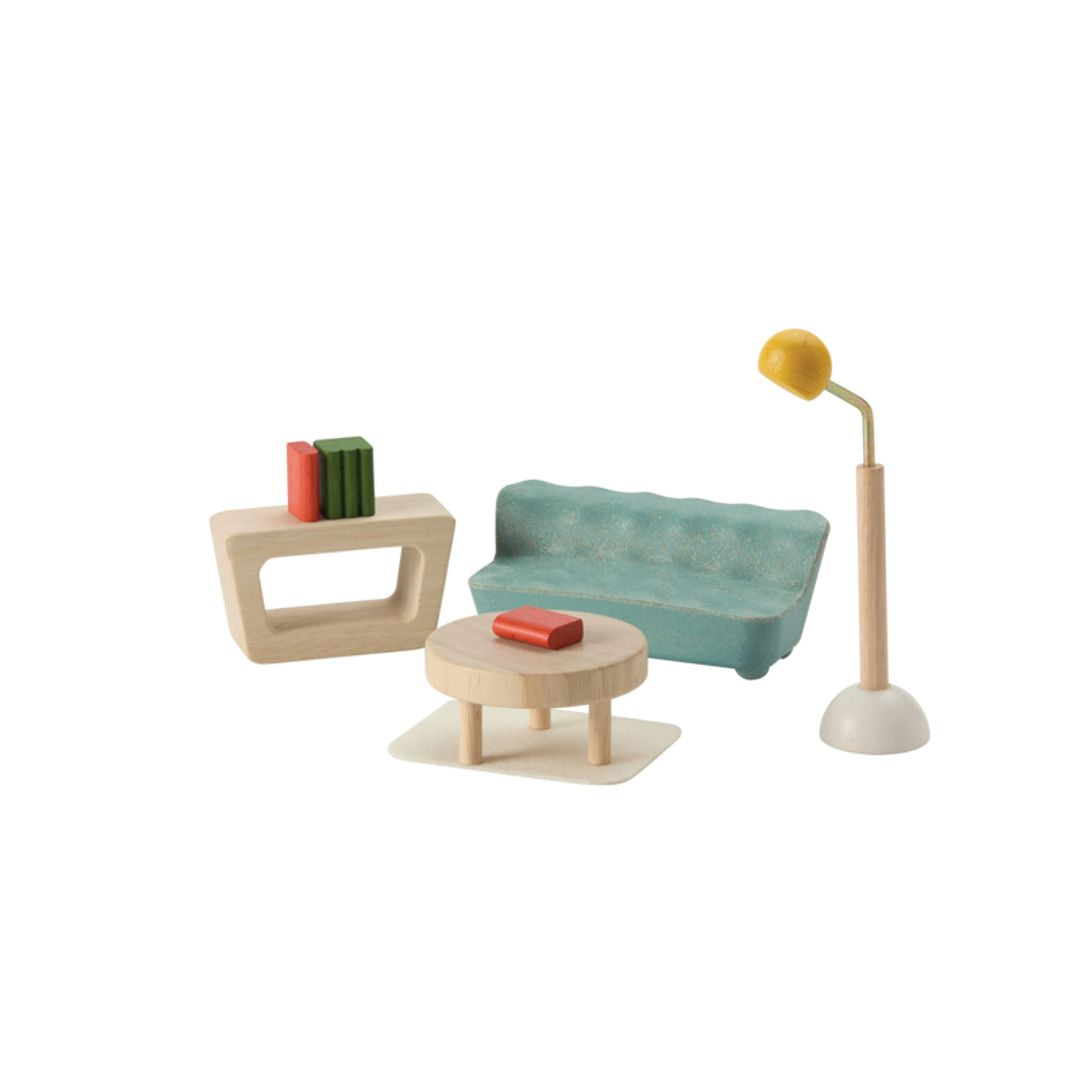 PlanToys PlanSpace modular dollhouse Living Room and Sunroom set, featuring a couch, coffee table, shelving, books, a floor lamp, and a small rug.
