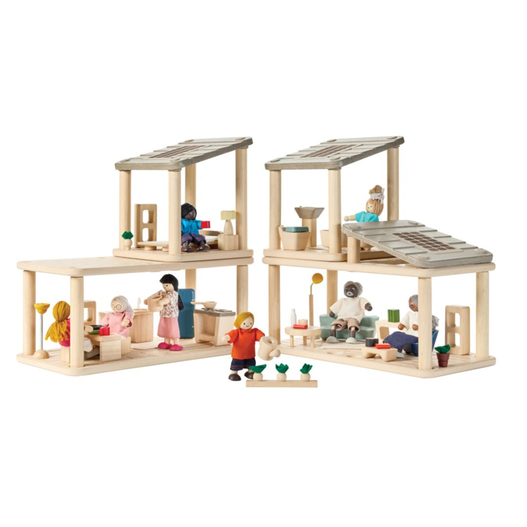 PlanToys PlanSpace modular wooden dollhouse setup featuring multiple wooden rooms with furniture, potted plants, and a modern open design with solar panels.