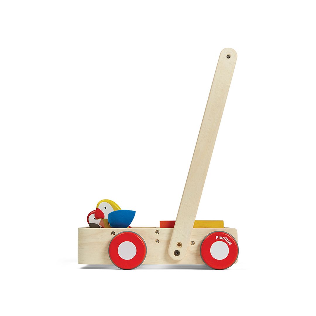 Side view of PlanToys Wooden Bird Walker Wagon, a push toy with two wooden birds, 10 colorful blocks, 6 natural blocks, and a sturdy handle for early walkers.