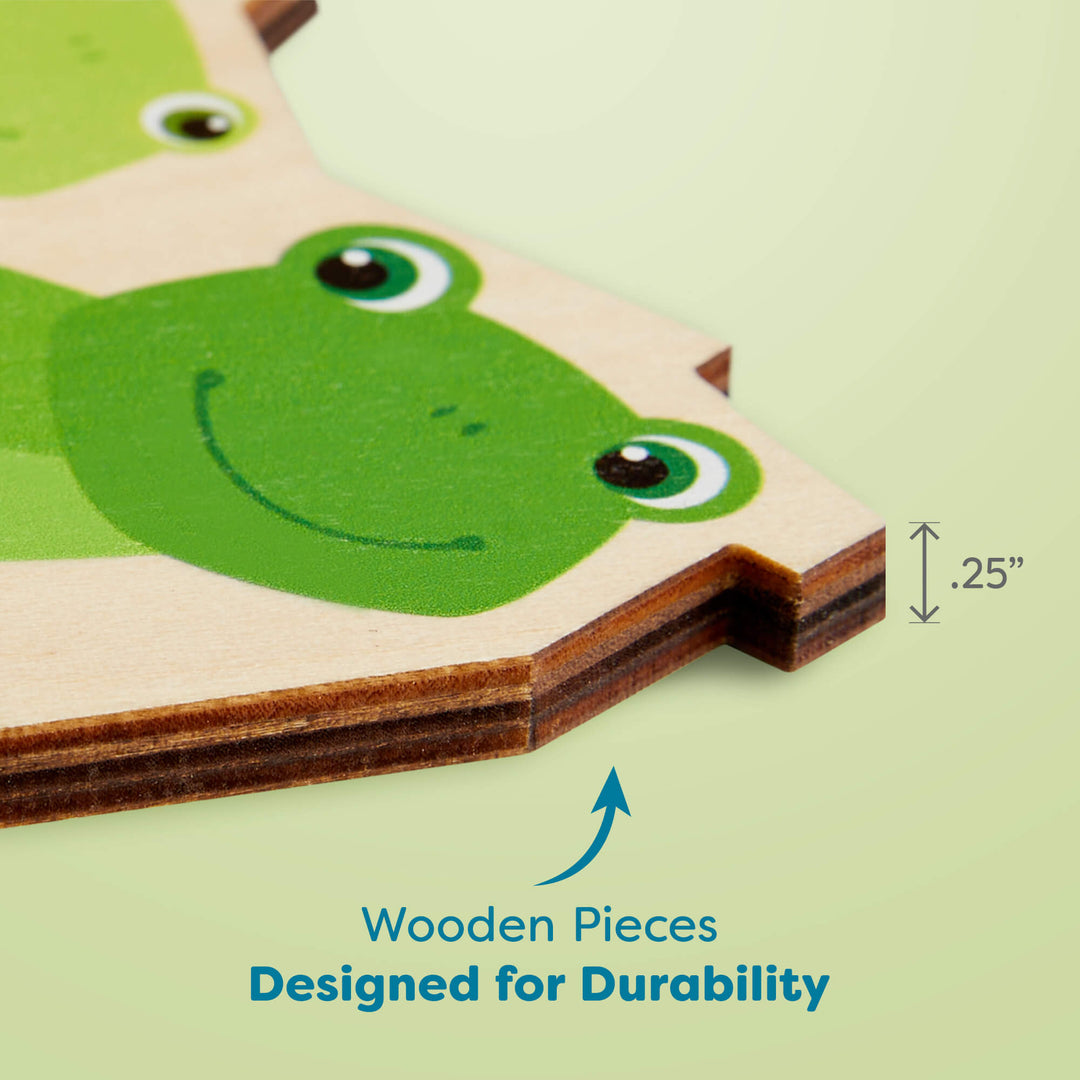 Close-up of a wooden puzzle piece featuring a green frog illustration, showing a labeled thickness of 0.25 inches. Text below reads "Wooden Pieces Designed for Durability"