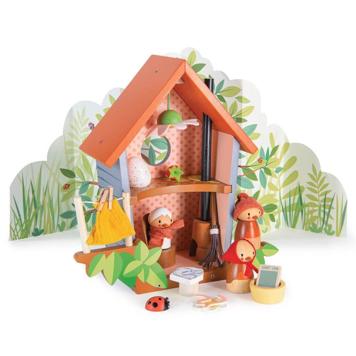 Wooden toy birdhouse set with a cabin and small figures on a white background