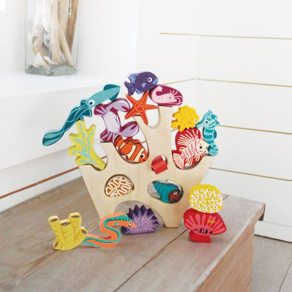 Colorful wooden sea creature stacking set on a wooden surface with a white wall background