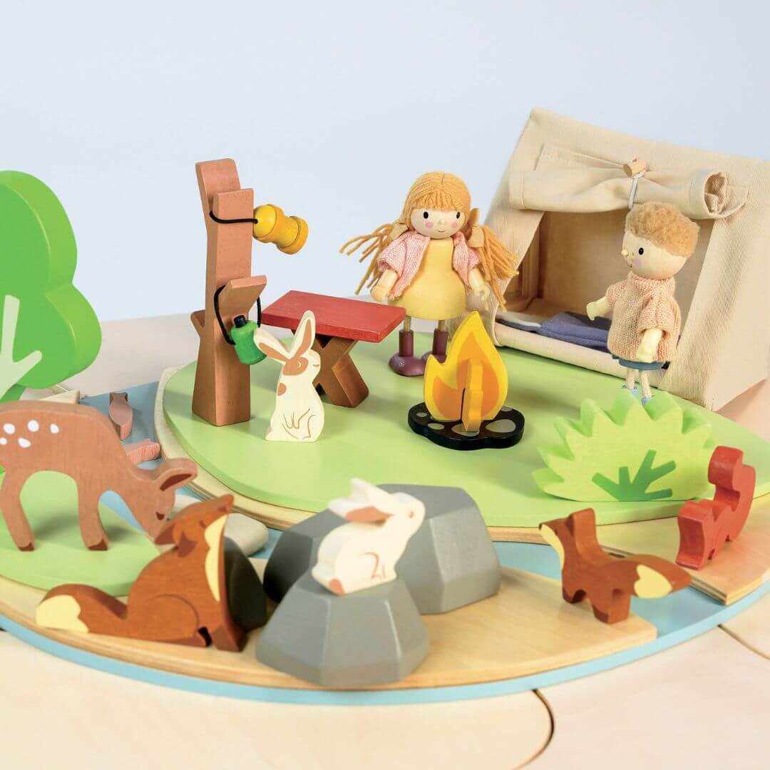 Wooden playset with camping scene including children, animals, and a campfire. Tender Leaf Toys