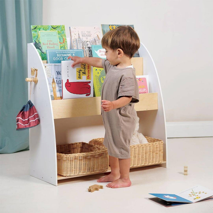 Child placing book into Tender Leaf Toys Forest Collection Wooden Book Shelf and Storage Unit