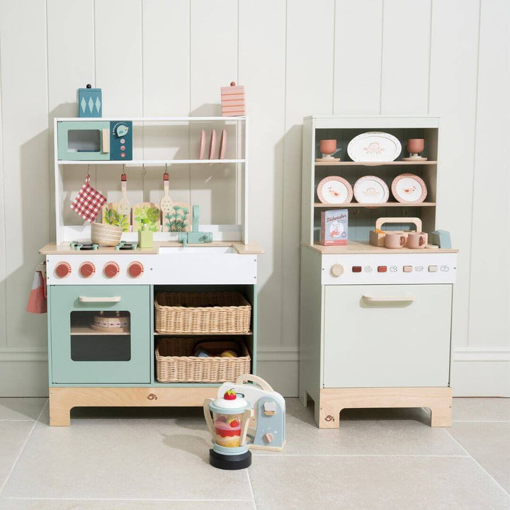 Tender Leaf Toys lay kitchen and dishwasher set in a room with a white wall and grey tile.