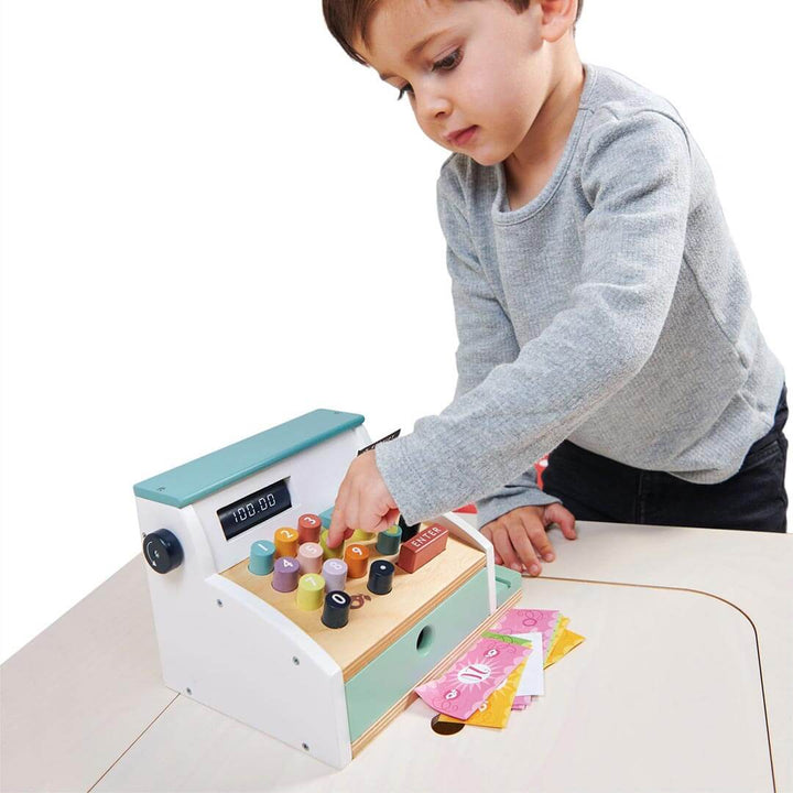 Kid pressing buttons on Tender Leaf Toys Wooden General Store Cash Register