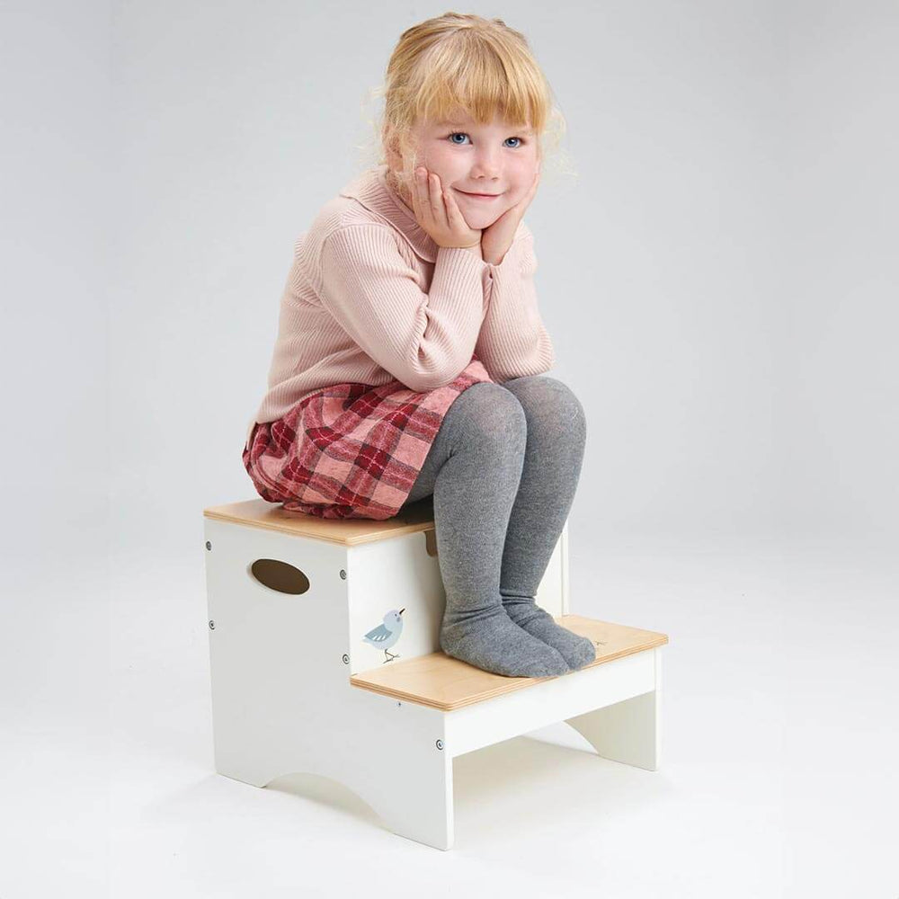 Girl sitting on Tender Leaf Toys Wooden Steps with Storage
