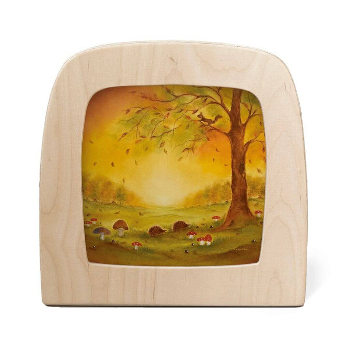Toverlux transparency Autumn Leaves by Baukje Exler featuring a
golden tree with falling leaves against a glowing sunset. Hedgehogs, mushrooms, and forest floor details create a warm and dreamy autumn scene.