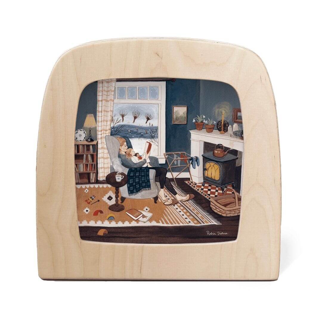 Toverlux Lamp Transparency – “Snow Day” by Robin Pieterse, from the Winter Collection. A cozy indoor scene with a woman reading by the fire while snow falls softly outside - Bella Luna Toys