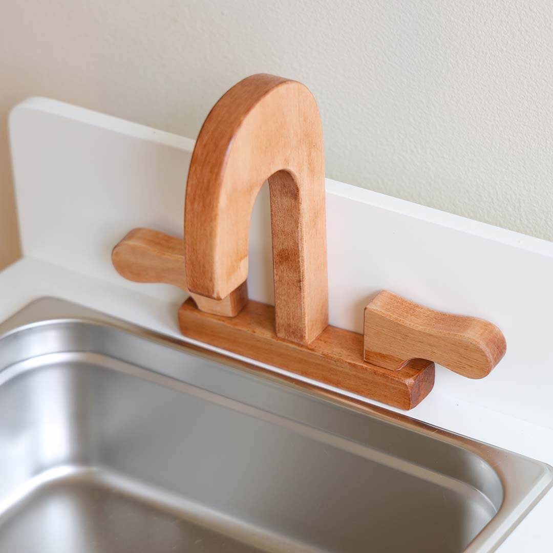 Wooden sink on a white kids kitchen.