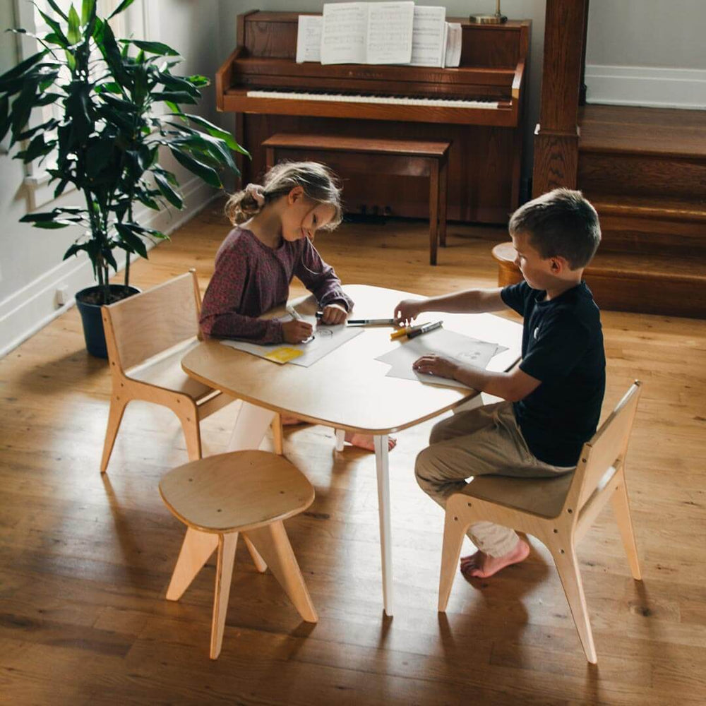Children sitting at Wooden Child's Table and Chair Set on wooden floor