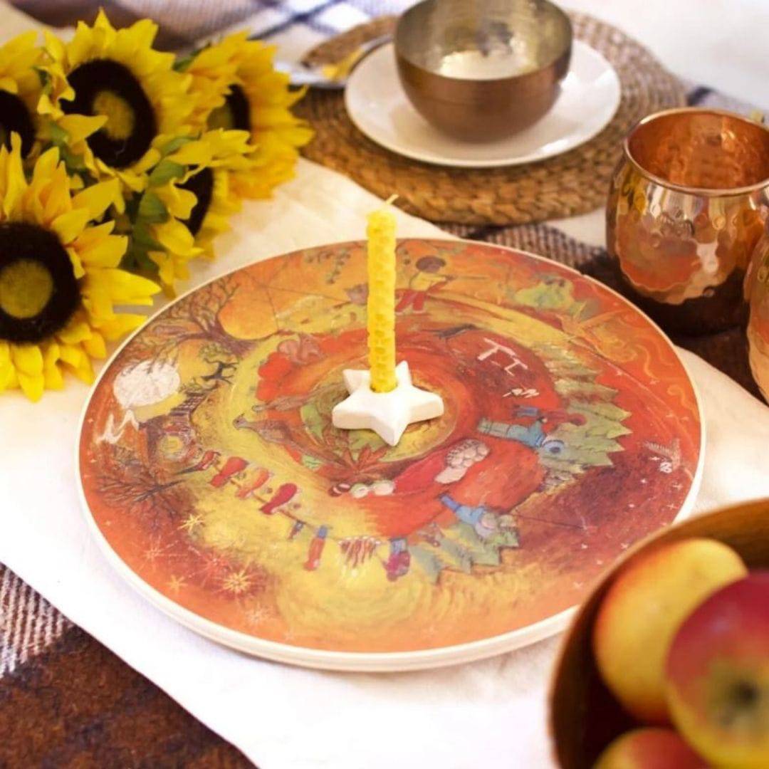 Autumn Wooden Wheel on table with star candle holder and candle, sunflowers, bowl of apples