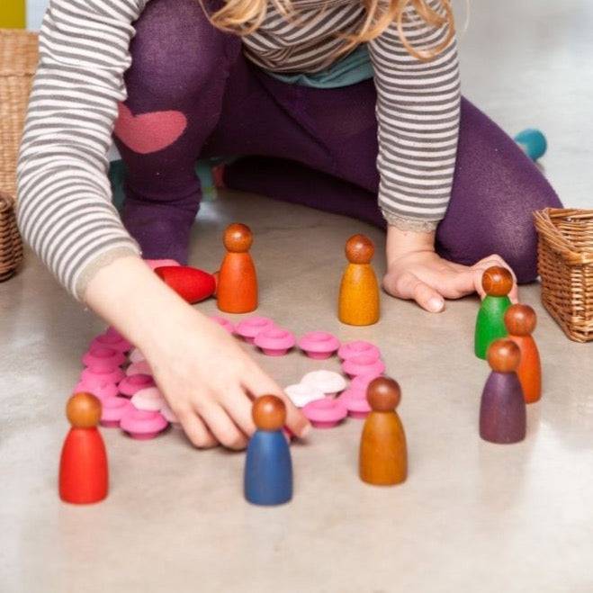 Child playing with Grapat wooden toys, including Dark Cold Nins Wooden Peg People