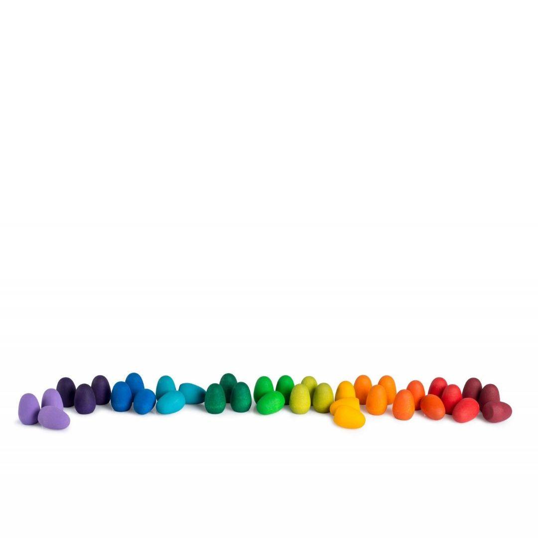 Grapat Mandala Wooden Rainbow Eggs organized by color in a somewhat organic line