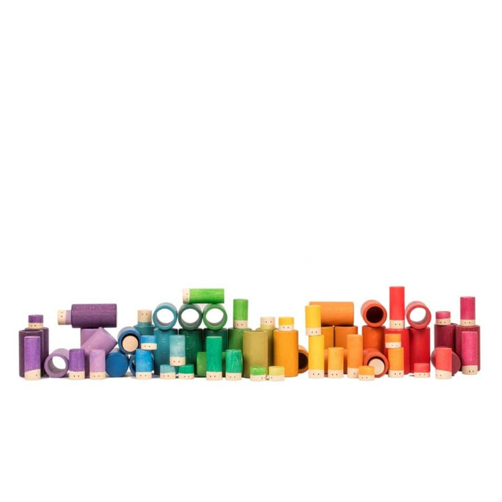 Wooden rainbow colored tubes and Lola pieces arranged in color order 