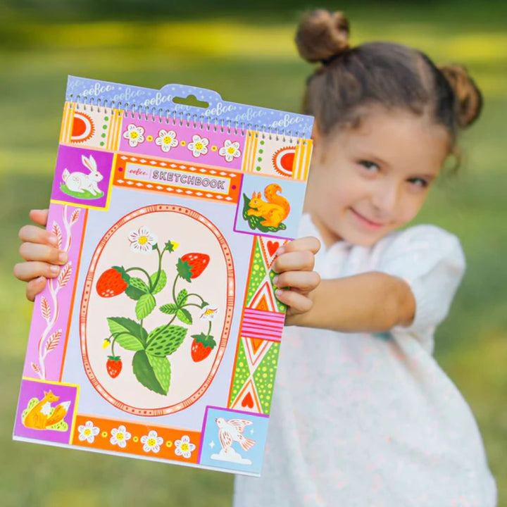 eeBoo- Child holding a sketchbook with a strawberry cover design- Bella Luna Toys
