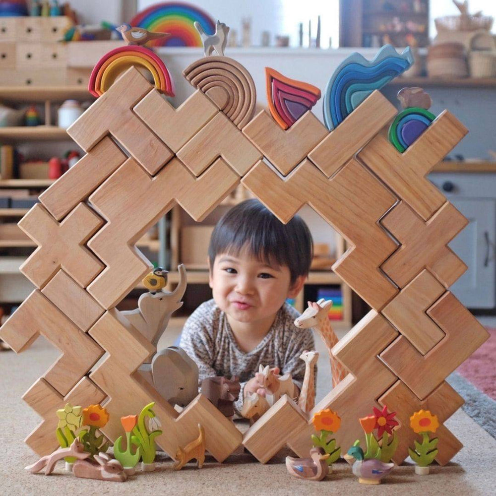 young child peering through window-like structure created from Grimm's Wooden Stairway Building Blocks Set