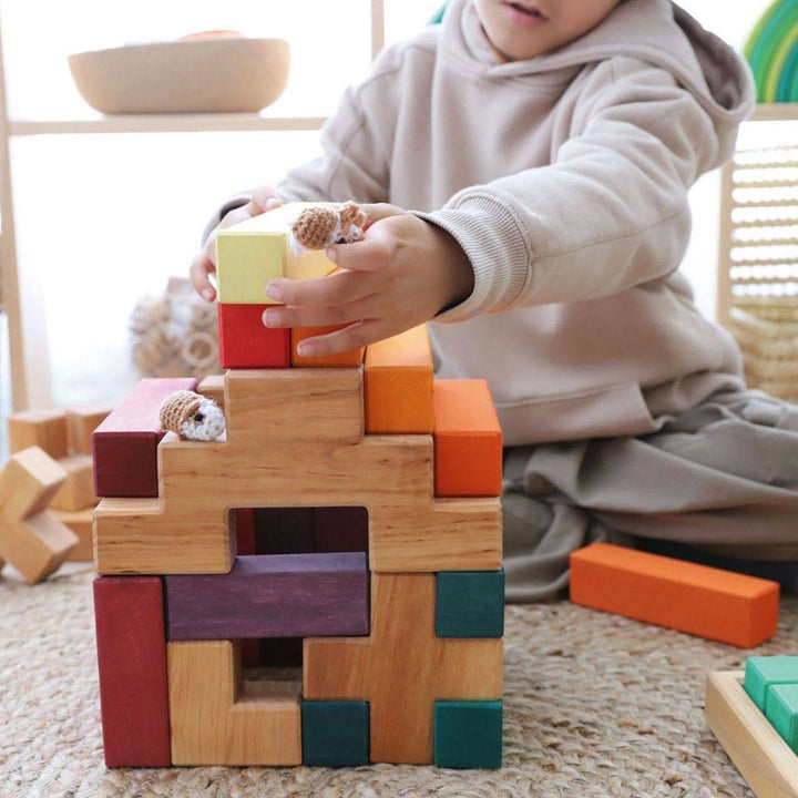 young child building with Grimm's Wooden Stairway Building Blocks Set