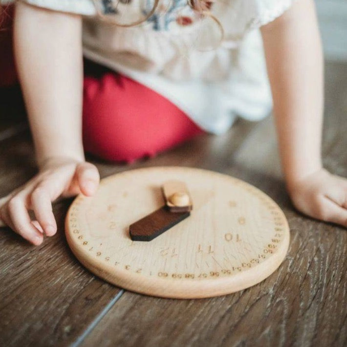 Mirus Toys- Child playing with wooden clock with wooden hands- Bella Luna Toys