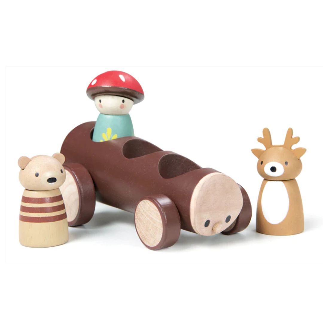 Tender Leaf Toys- Wooden tree log taxi with wooden figurine in blue shirt, wearing red and white mushroom hat. Wooden toy bear and deer standing outside of taxi- Bella Luna Toys