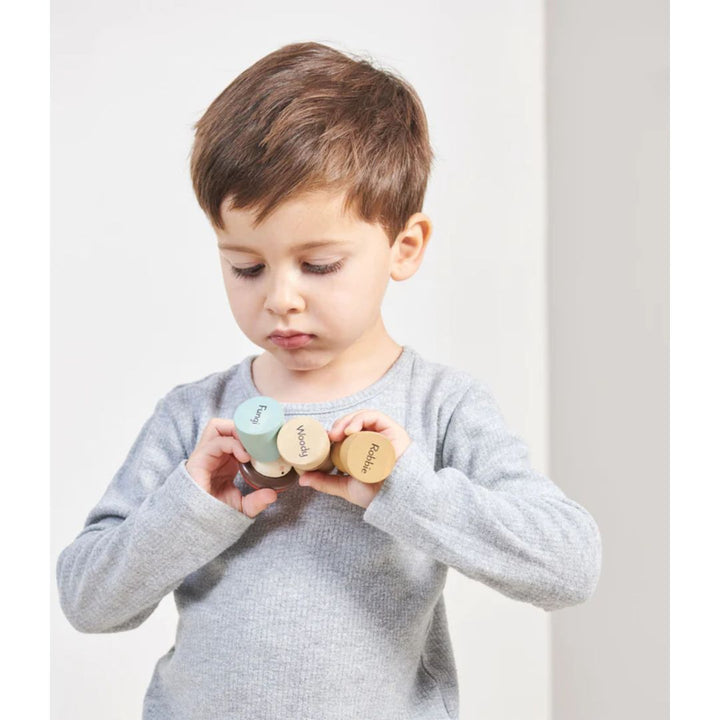 Tender Leaf Toys- Child holding wooden figurines upside-down with the names Woody and Robbie written on the bottom of figurines- Bella Luna Toys