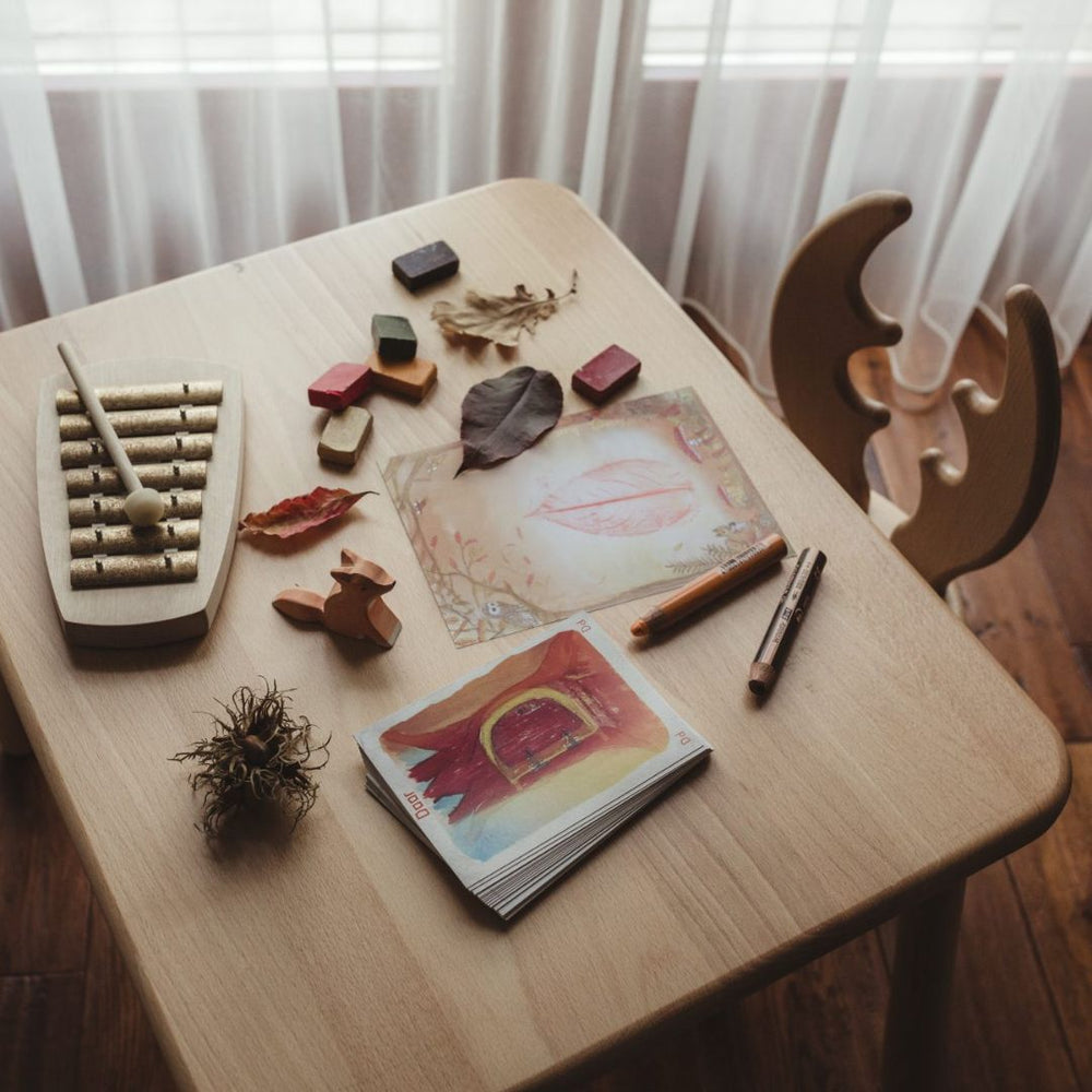 Picture of a Waldorf inspired children's workspace with instrument, wooden toys and colorings- Bella Luna Toys